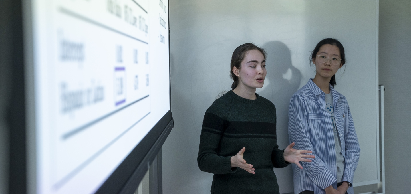 Young person talking in front of screen