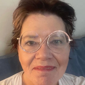 Portrait of Cathy Hews with beige and blue background