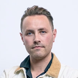 portrait photo of Lorenzo Conte, tan collar, cream jacket with a off white background